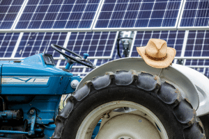 Cowboy hat sitting on tractor tire in front of solar panels